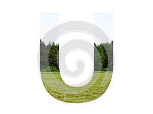 Letter U of the alphabet made with landscape with grass, forest and a blue sky