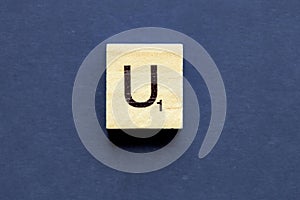 Letter U on a wooden cube from a wordplay board game
