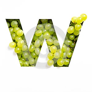 Letter W of English alphabet of green grape and cut paper isolated on white. Natural typeface of fresh berries