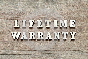 Letter in word lifetime warranty on wood background