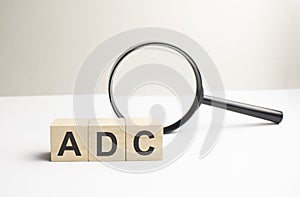 Lettering ADC on wooden cubes on a gray background photo
