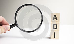 Lettering adi on wooden cubes on a gray background