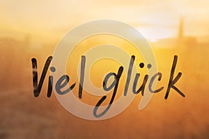 Lettering Deutsch language text Viel gluck is Good luck in english message written finger on foggy glass wet sunset