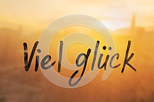 Lettering Deutsch language text Viel gluck is Good luck in english message written finger on foggy glass wet sunset photo