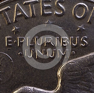 Lettering E Pluribus Unum, one out of many, on the reverse of the one dollar USA coin issued in 1978, isolated on the black photo