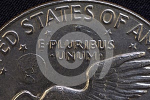 Lettering E Pluribus Unum, one out of many, on the reverse of the one dollar USA coin issued in 1978, isolated on the