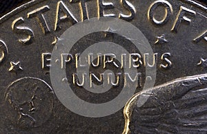 Lettering E Pluribus Unum, one out of many, on the reverse of the one dollar USA coin issued in 1978, isolated on the black