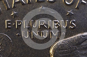 Lettering E Pluribus Unum, one out of many, on the reverse of the one dollar USA coin issued in 1978, isolated on the black