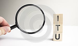 Lettering ITU on wooden cubes on a gray background