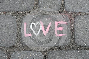 Lettering LOVE made iwith chalk on the road