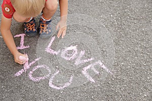 Lettering and love you with pink chalk on gray asphalt