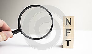 Lettering NFT on wooden cubes on a gray background