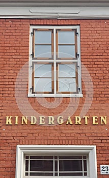 lettering tag Kindergarten on red wall of bricks