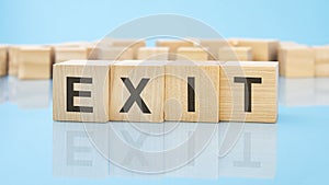 letters Exit made with wood building blocks. blue background. business concept