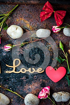 Letters LOVE on rustic background with hearts and flowers