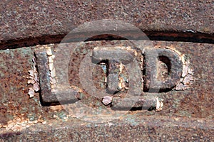 Letters LTD on the rusty surface of an old retro machineries