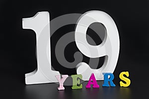 Letters and numbers nineteen years old on a black background.