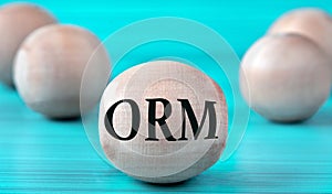 The letters ORM are depicted on a wooden round ball on a blue background