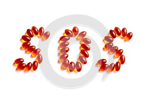 The letters SOS written in orange and red vitamins and pills on a white background.