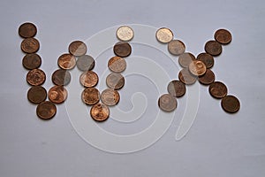 Letters w x of copper coins insulated on a white sheet of paper.