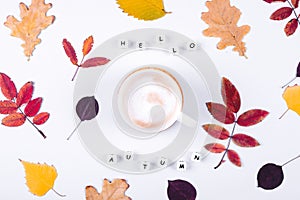 Letters words Hello Autumn and cup of coffee on grey background. Colorful autumn leaf. Flat lay