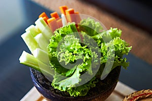 Lettuce ,cucumber and carots sliced in wooden bowl in natural diet concept