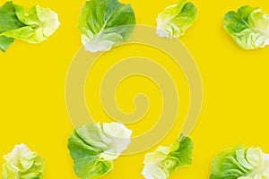 Lettuce leaves on yellow background. Copy space