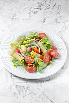Lettuce tomato cherry salad with penne pasta