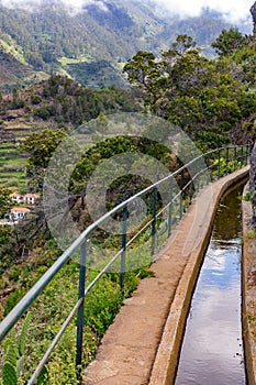 Levada hiking trail secured with a railing in the mountains of Madeira