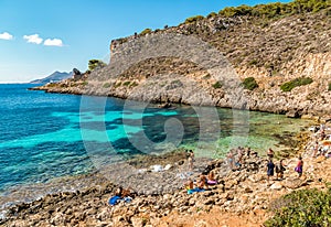 Visitors enjoying the Cala Fredda beach during their trip on the Levanzo island in the Mediterranean sea of Sicily.