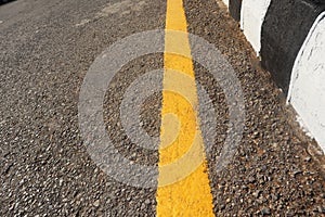 Level asphalted road with dividing yellow stripes. The texture of the tarmac, top view-asphalt with a distinct yellow stripe