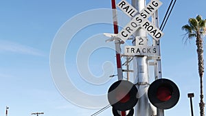 Level crossing warning signal in USA. Crossbuck notice and red traffic light on rail road intersection in California