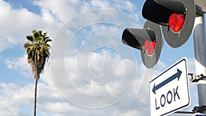 Level crossing warning signal in USA. Crossbuck notice and red traffic light on rail road intersection in California. Railway