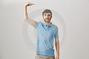 Level of sales has increased incredibly. Studio shot of positive glad caucasian male office worker raising hand and