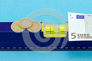Level tool euro banknote coin on blue