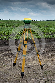 leveler tripod GPS equipment mounted on tripod in green organic field. GPS, GIS equipment