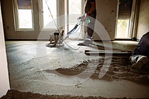 Leveling floor screed over floor heating system in residential building under construction