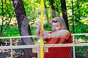 Levelling a new wooden domestic chicken coop built on a farm with a metal mesh inside using a level worker