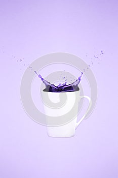 Levitating coffee mug with splashes. Coffee concept. Minimal art