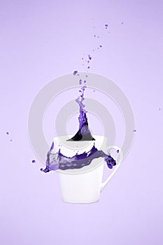 Levitating coffee mug with splashes. Coffee concept. Minimal art