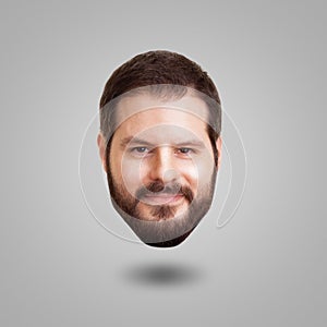 Levitating head of a bearded smiling man isolated on grey background. Creativity, cleverness and intelligence concept