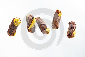Levitating mici or mitititei (traditional romanian food) with mustard on white background photo