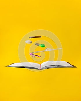 Levitating school supplies for math - notebook, pen, ruler, pencil, divider and eraser on yellow background. Concept of education