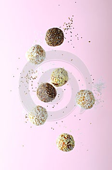 Levitating Vegan Sweets, Delicious Candy Balls with seeds, nuts and dried fruit, Healthy Candies on Pink Background