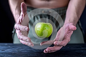 Levitation fresh green apple on a wooden table.