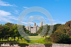 Lews Castle on estate landscape in Stornoway, United Kingdom. Castle with green grounds on blue sky. Victorian style photo