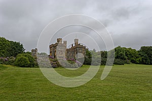 Lews castle set above the Town of Stornoway in the Outer Hebrides sitting on a grassy incline under flowering Azaleas photo