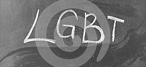 LGBT, abbreviation for LGBT. A symbol of free love. Hand written letters in white chalk on a school blackboard. Black and white