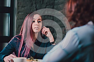 LGBT Cheerful female friends chatting in cafe. Two beautiful young women gossiping and drinking coffee. Friendship