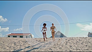 Lgbt couple running beach in bikini. Happy girls spending summer at ocean shore